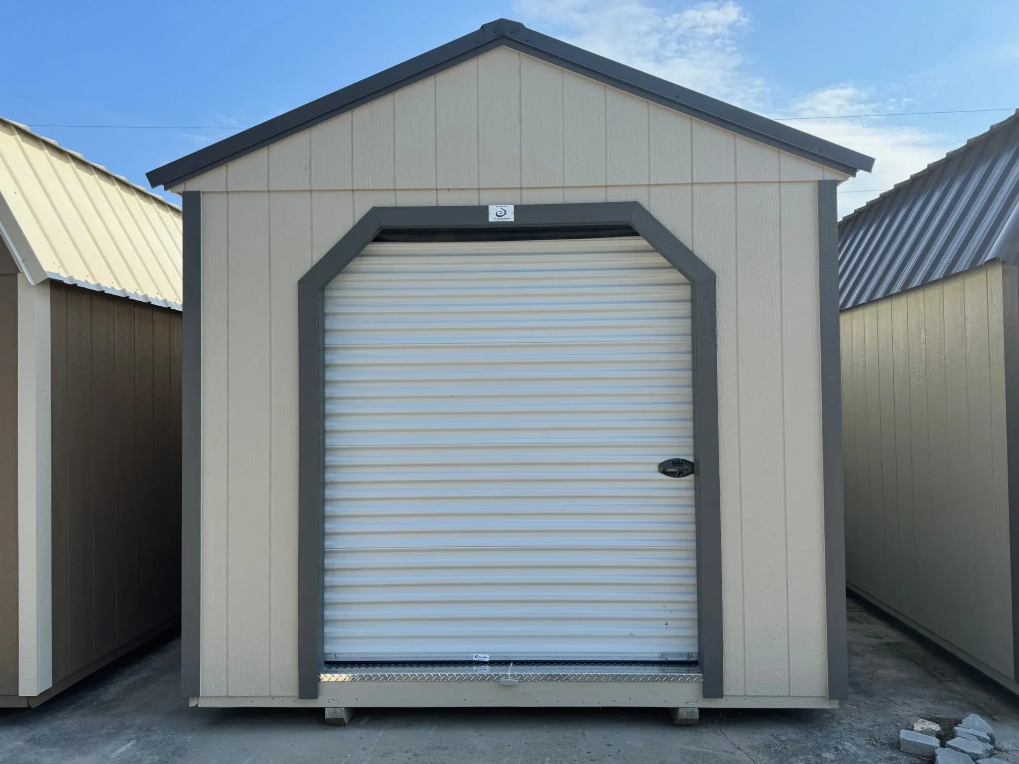 the front of a wood garage shed with an 8x6 rollup door in the front