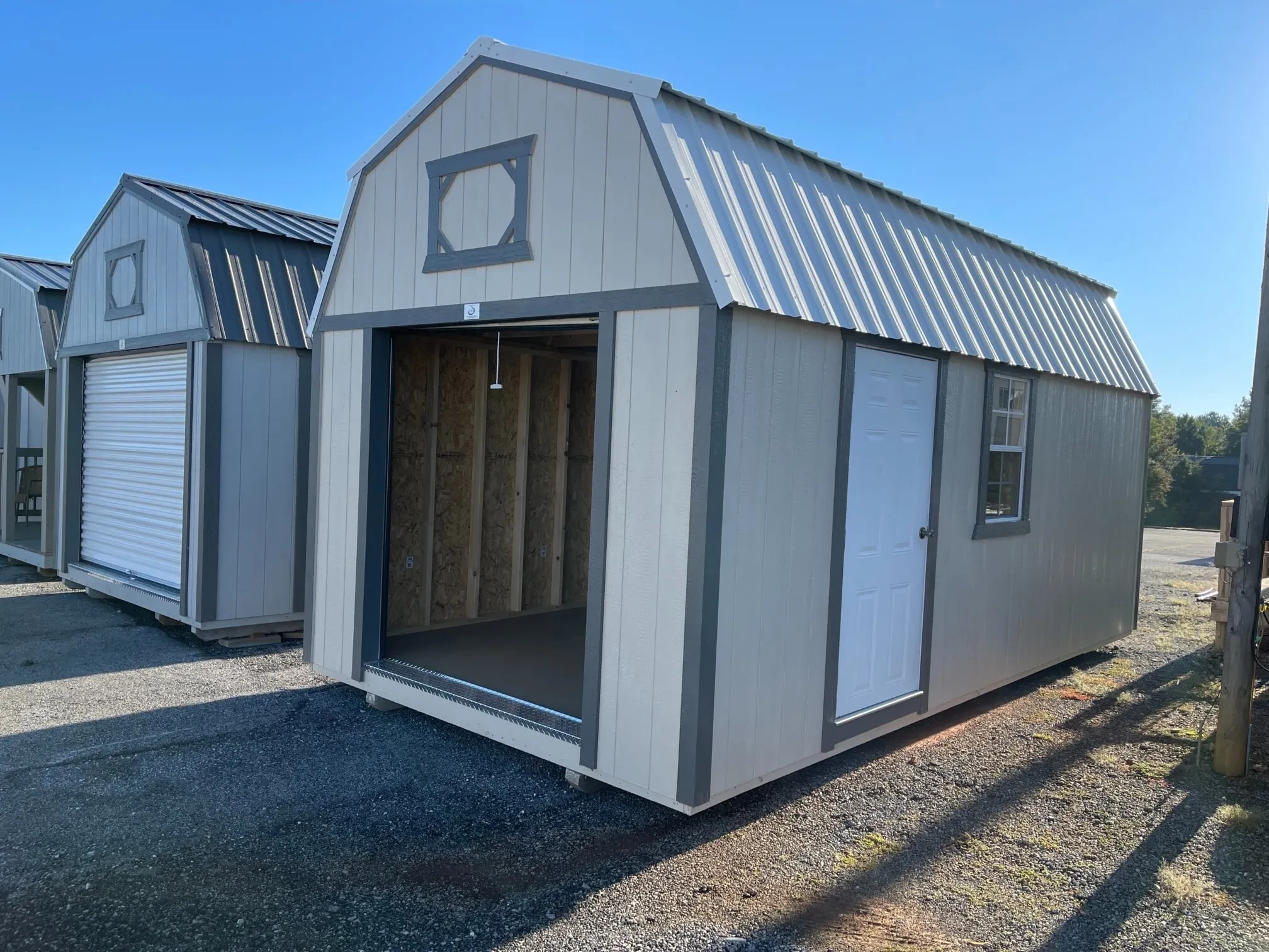 a wood lofted garage with the 6x7 rollup door open, it has a walk-in door and a 2x3 window on the right wall