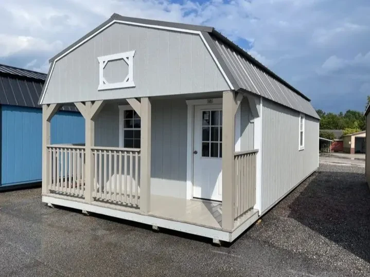 a lofted cabin shed with a 4' porch on the front and a walk-in door and several windows