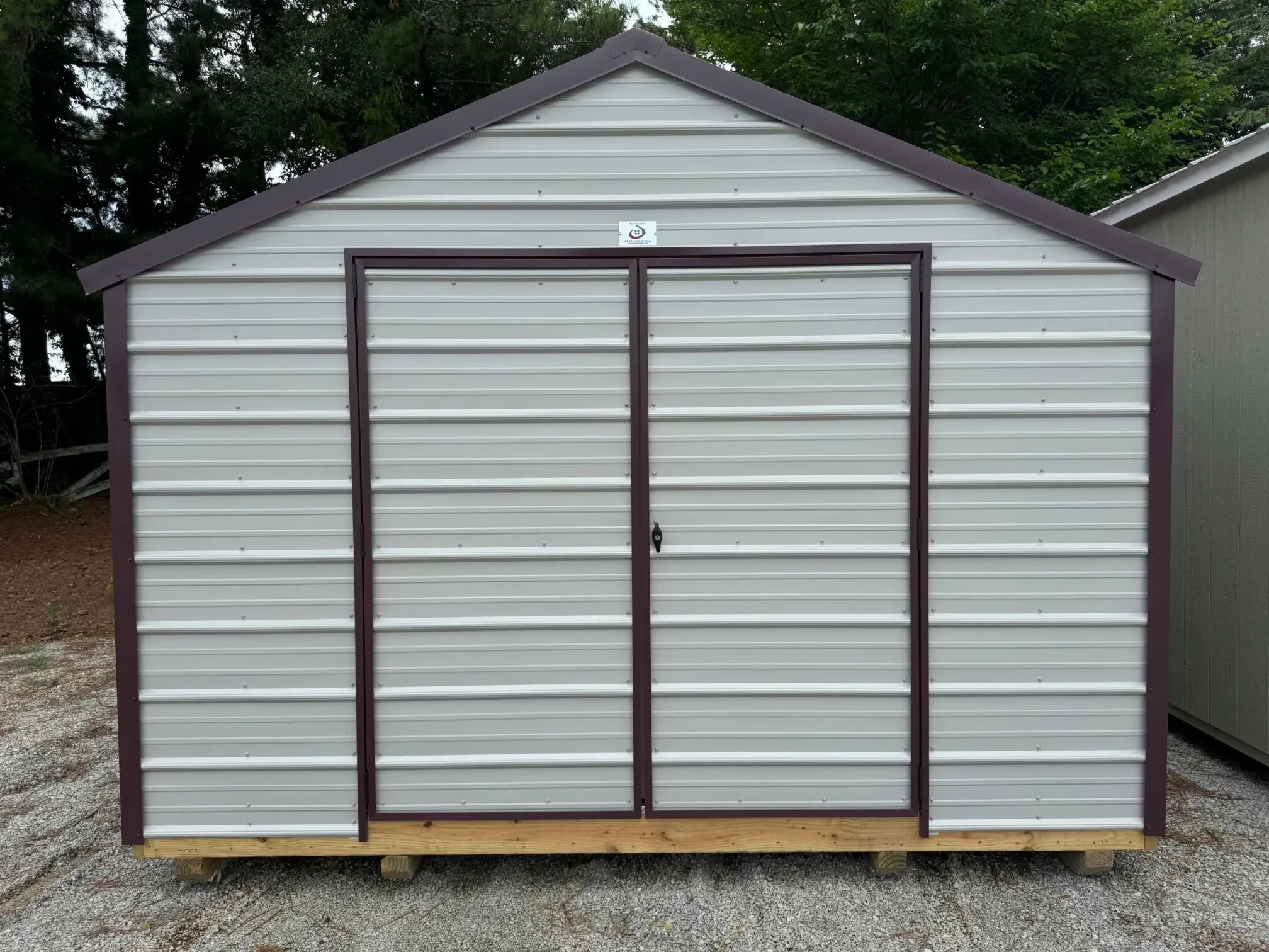 a gray metal shed with 72" double doors and burgundy colored trim