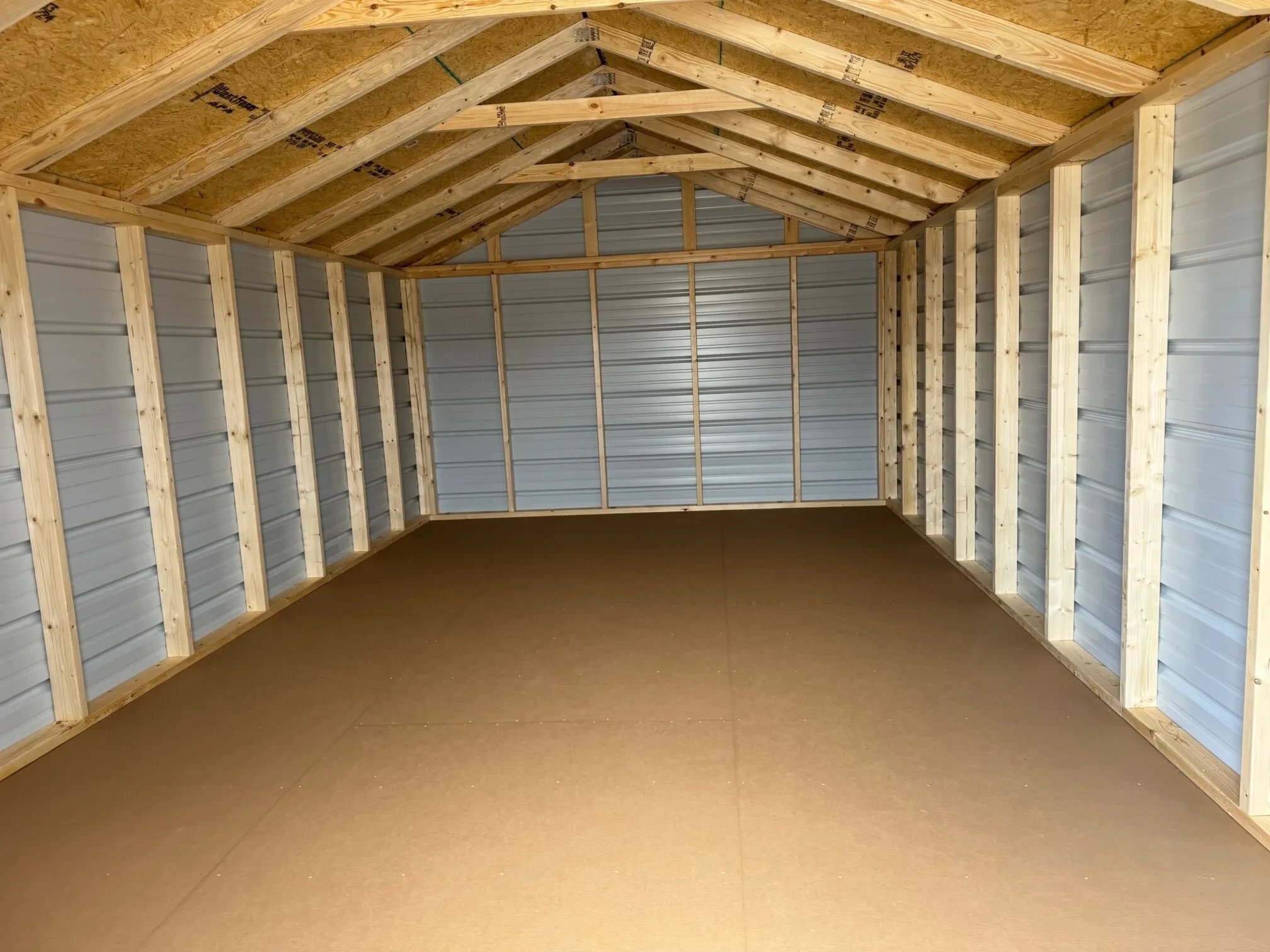 inside a 12' wide metal shed with a solid floor and the framing visible