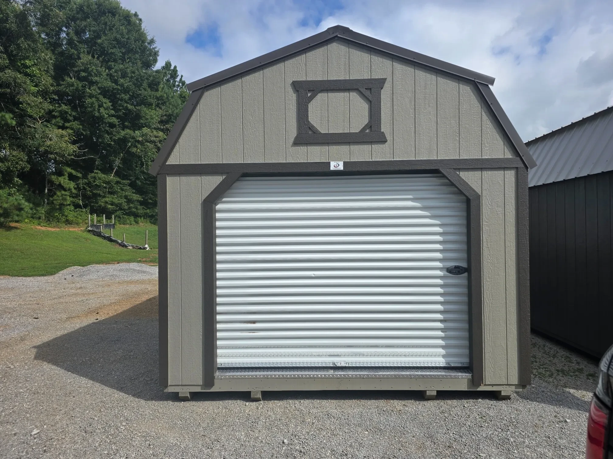 a 12' wide lofted garage with an 8x7 rollup door in the front which is closed
