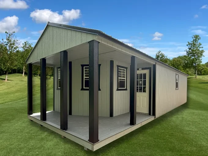 a fancy shed with a L shaped porch with a walk-in door and many windows