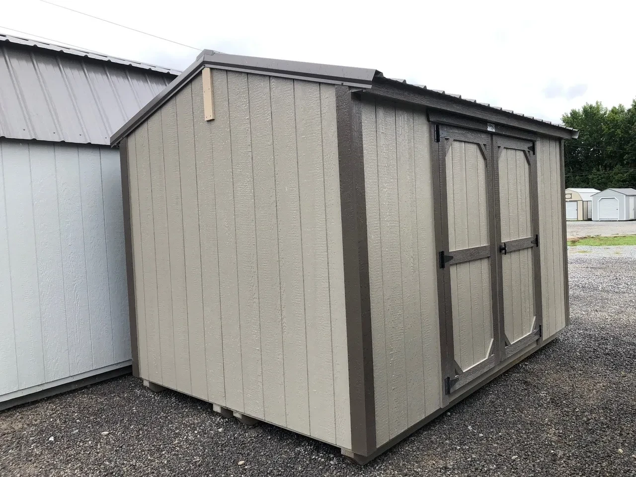 a clay colored wood shed that is split in half so it can fit between small gates