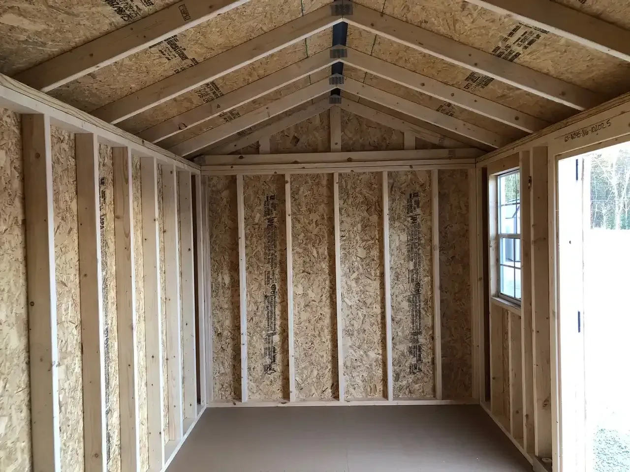 the interior of a wood garden shed with a window in view