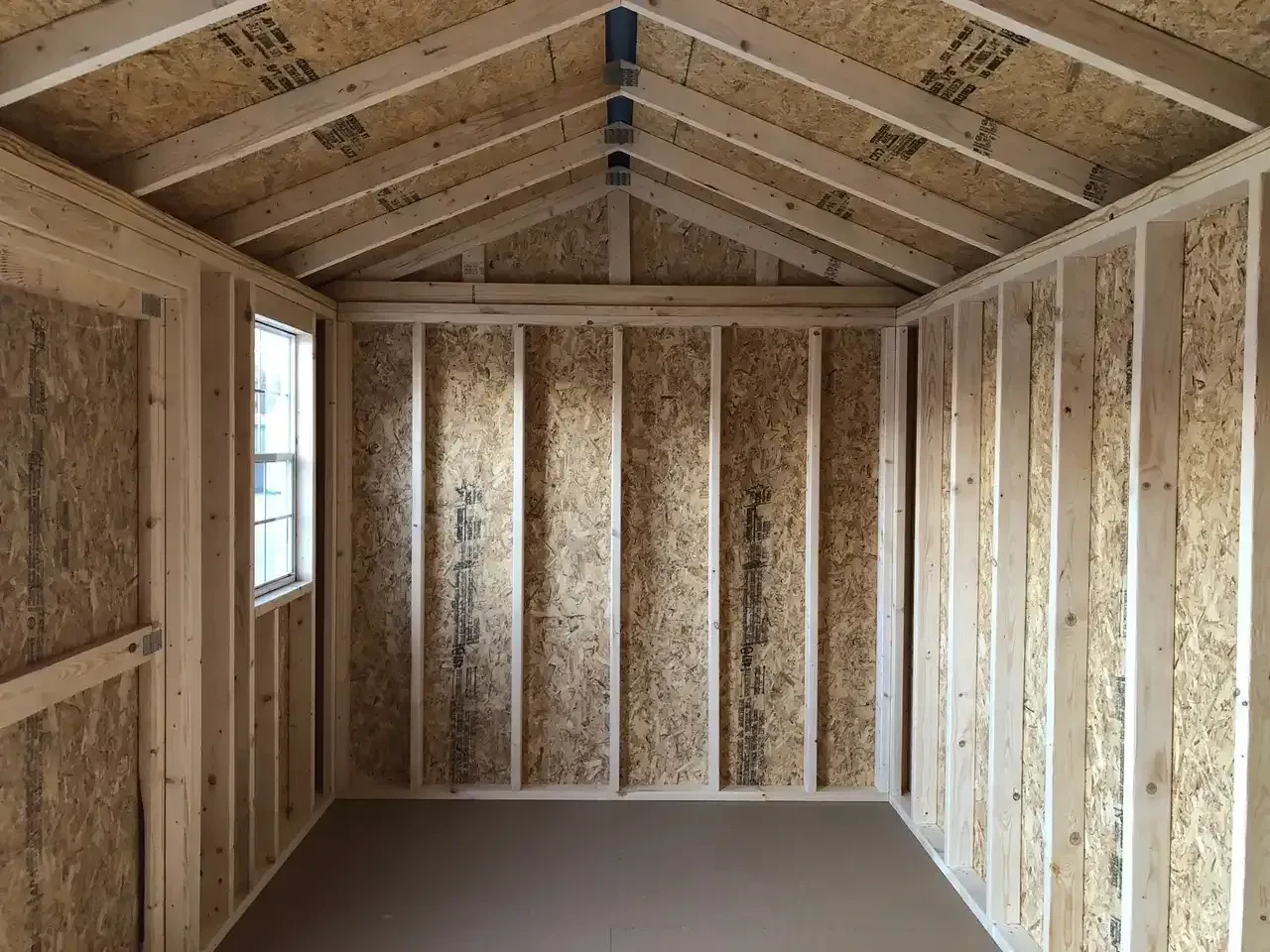 the left side of the interior of a wood garden shed showing a solid floor