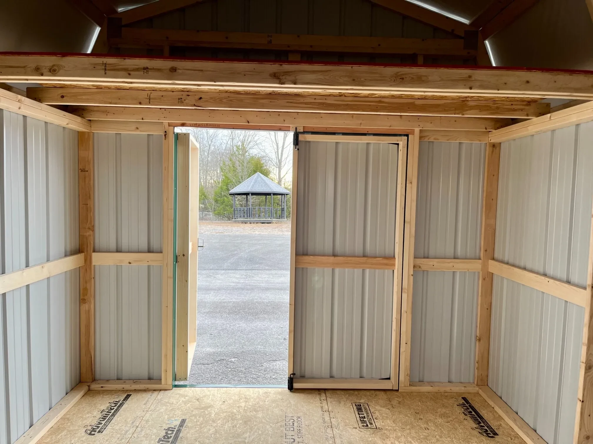 double doors which are open under a 4' loft inside a metal lofted barn