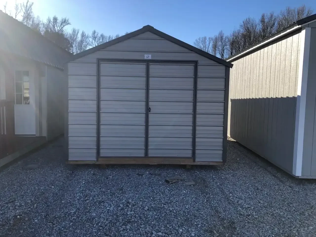 a gray metal shed with double doors and horizontal metal on the walls and doors