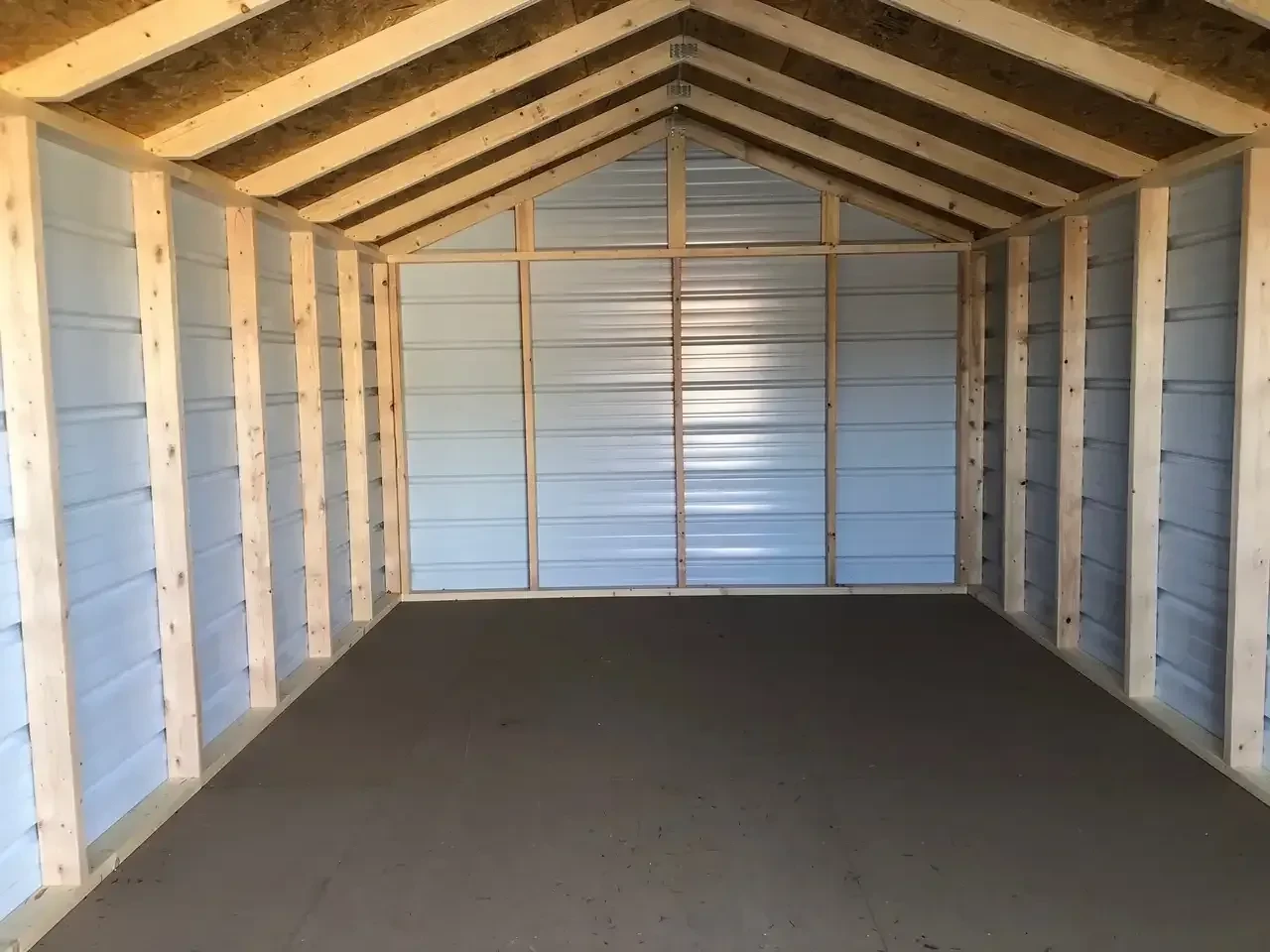 the interior of a metal shed showing the wood framing and a solid floor