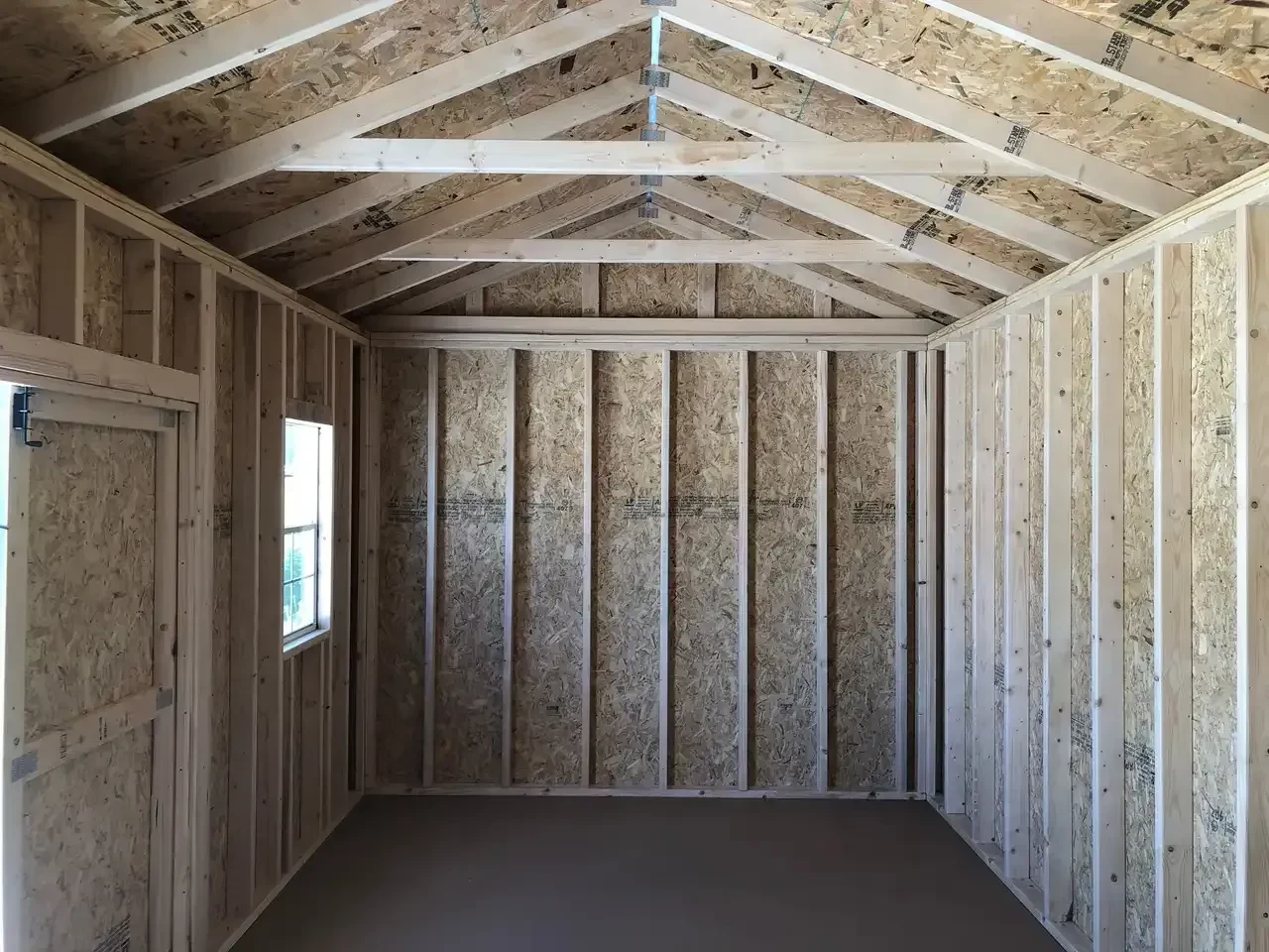 the left side of a wood garden shed showing a window in the front