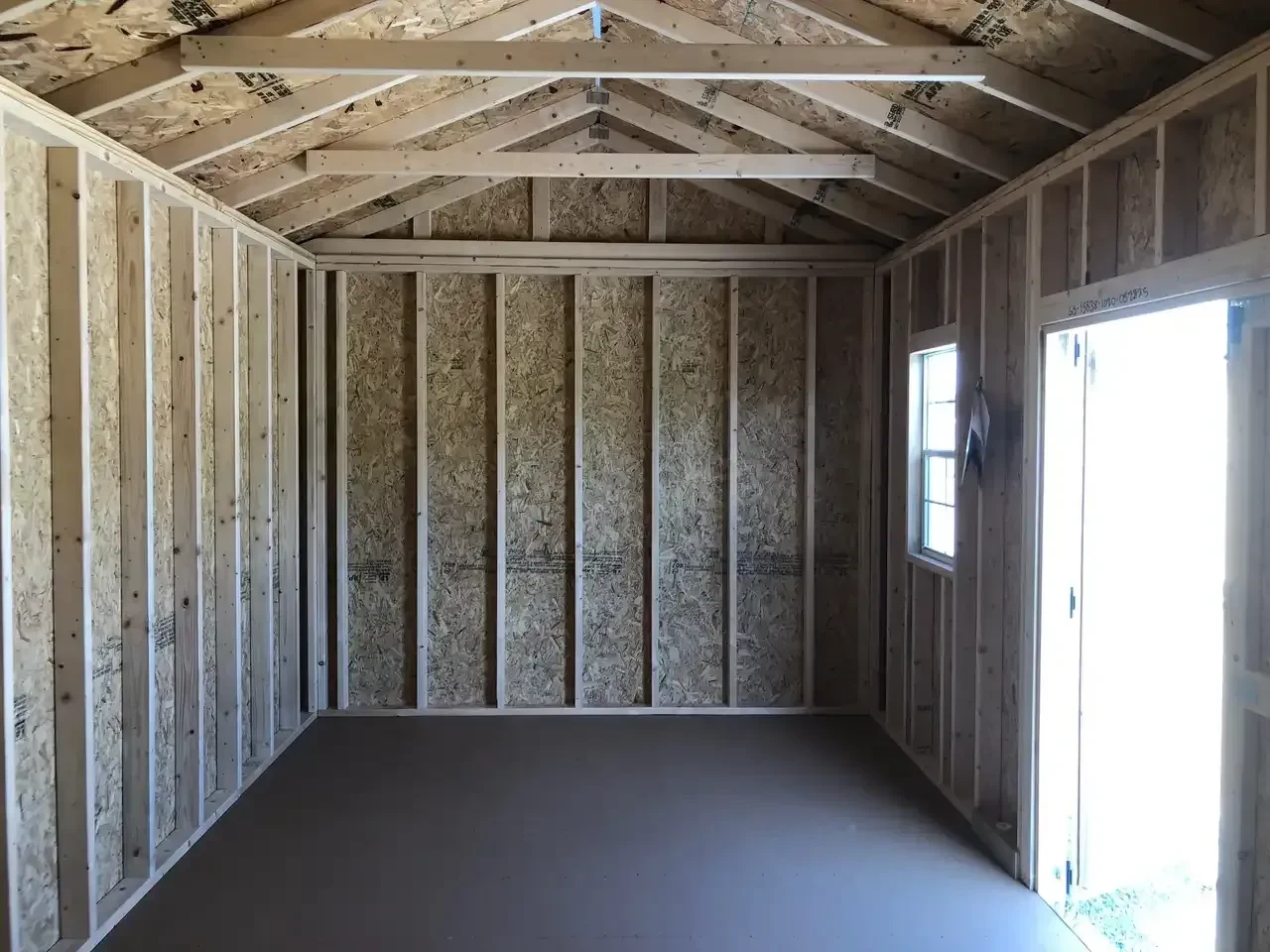 the right side of a wood garden shed showing a window in the front
