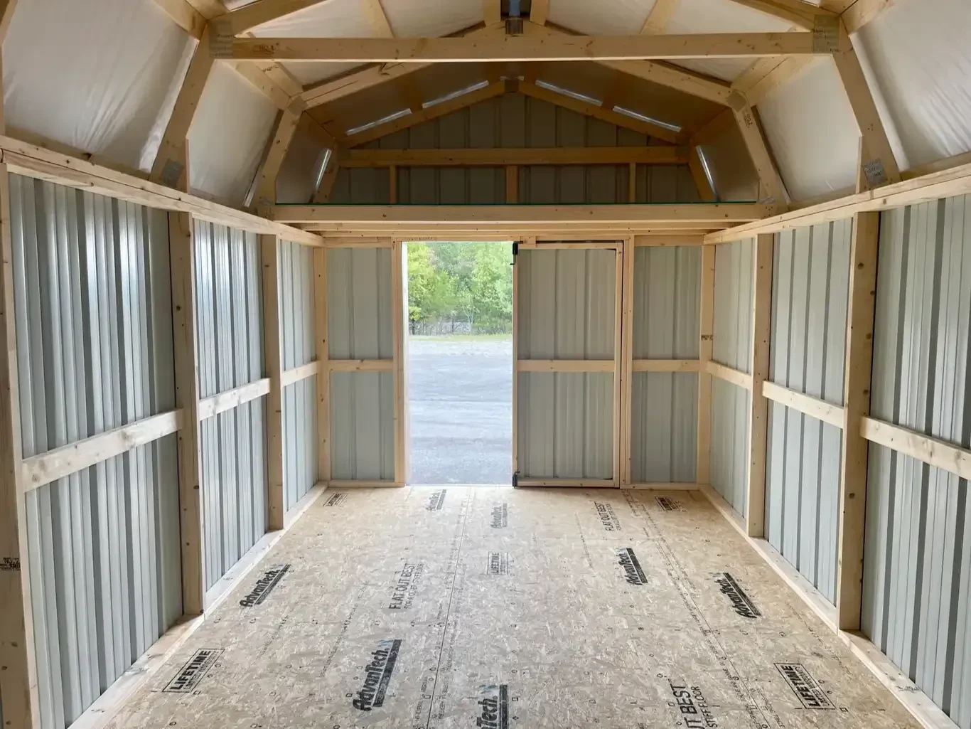 a loft above an open door from inside a metal lofted barn