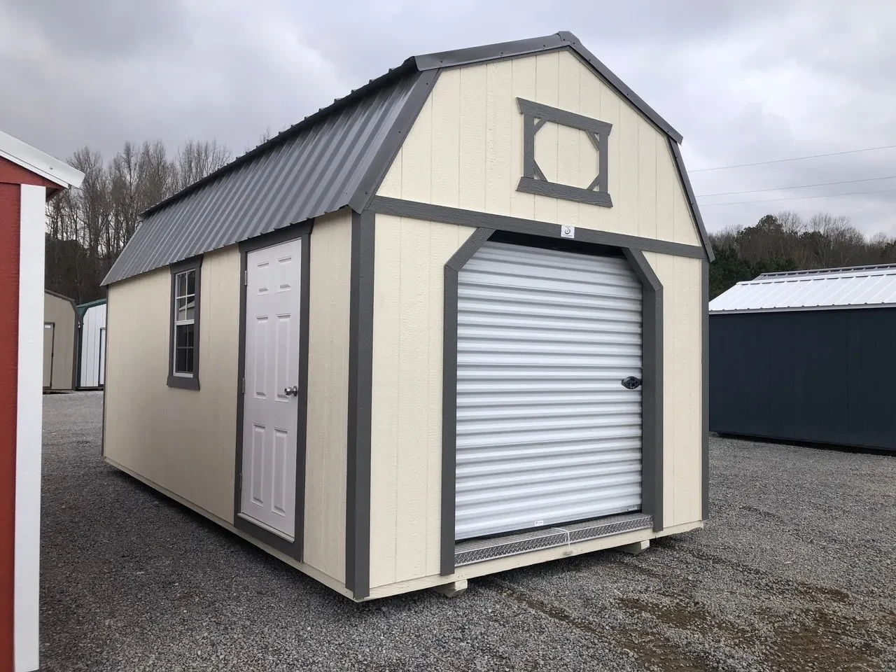 an ivory colored lofted garage with a 6x7 rollup door closed and a walk-in door and a window on the left wall