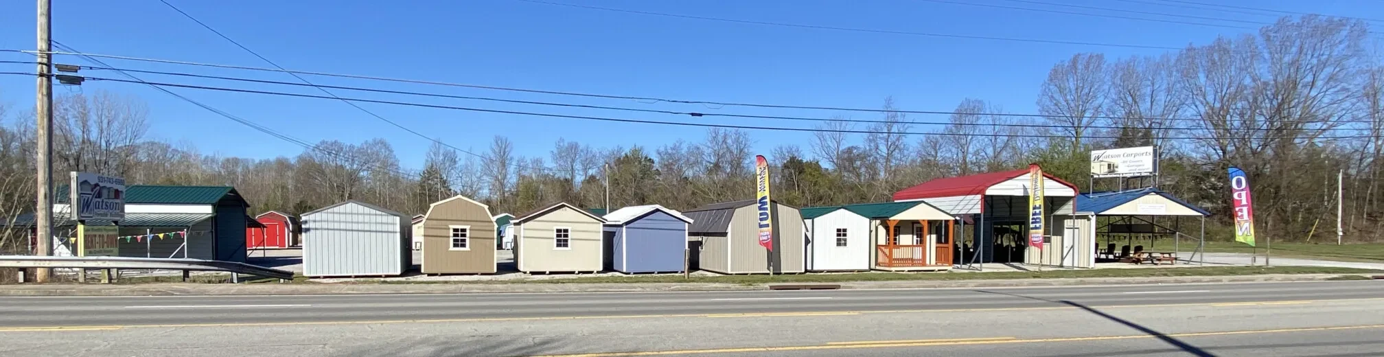 row of sheds and carports on McMinnville sales lot as seen from the road