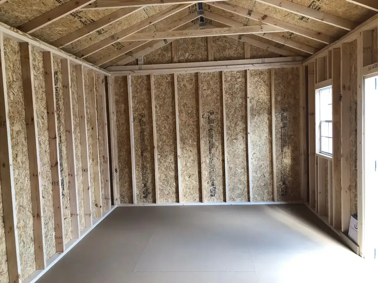 the right ride interior of a wood garden shed showing a window on the front wall