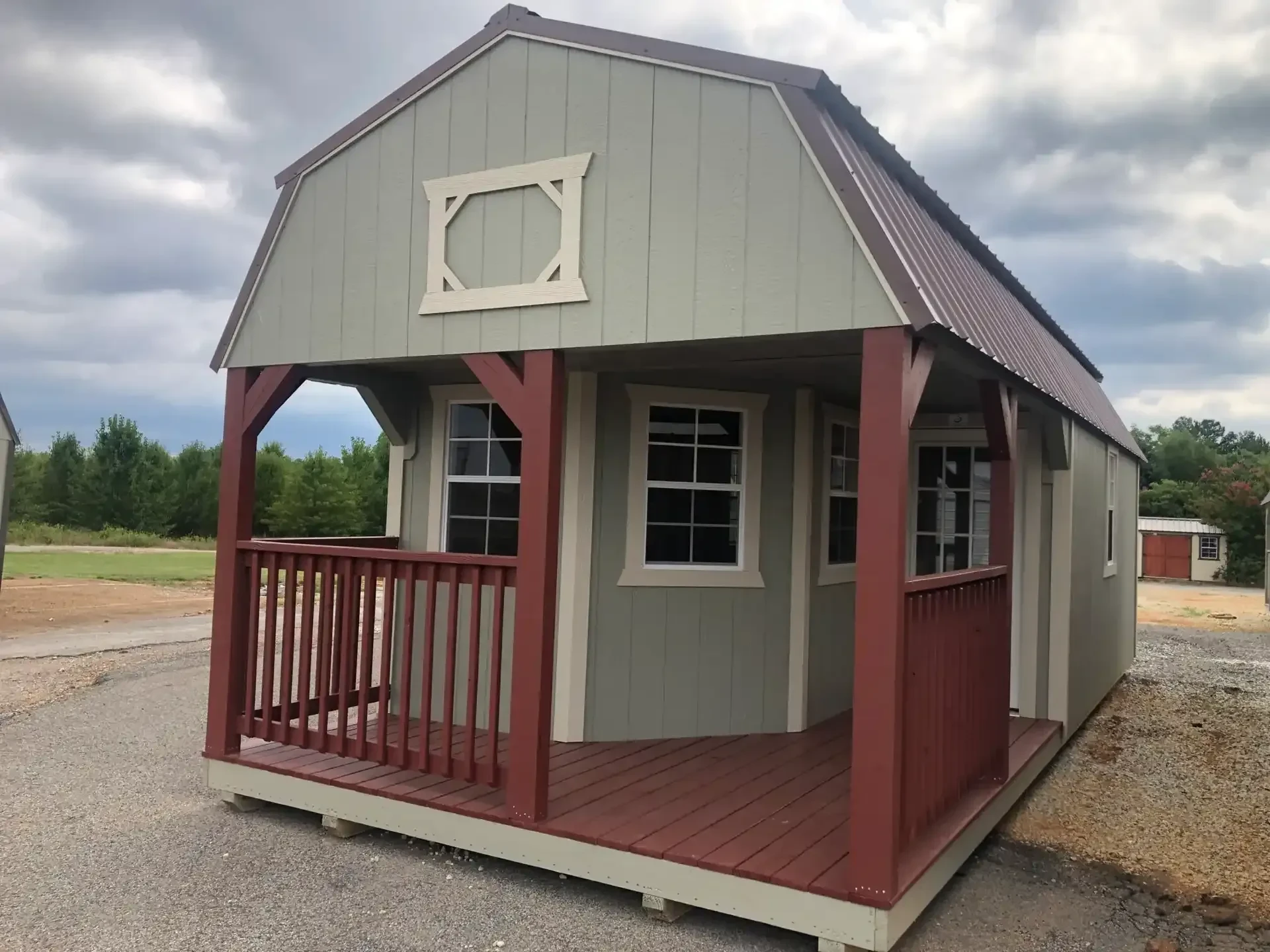 a clay colored lofted cabin with a red dutch style porch and multiple 2x3 windows