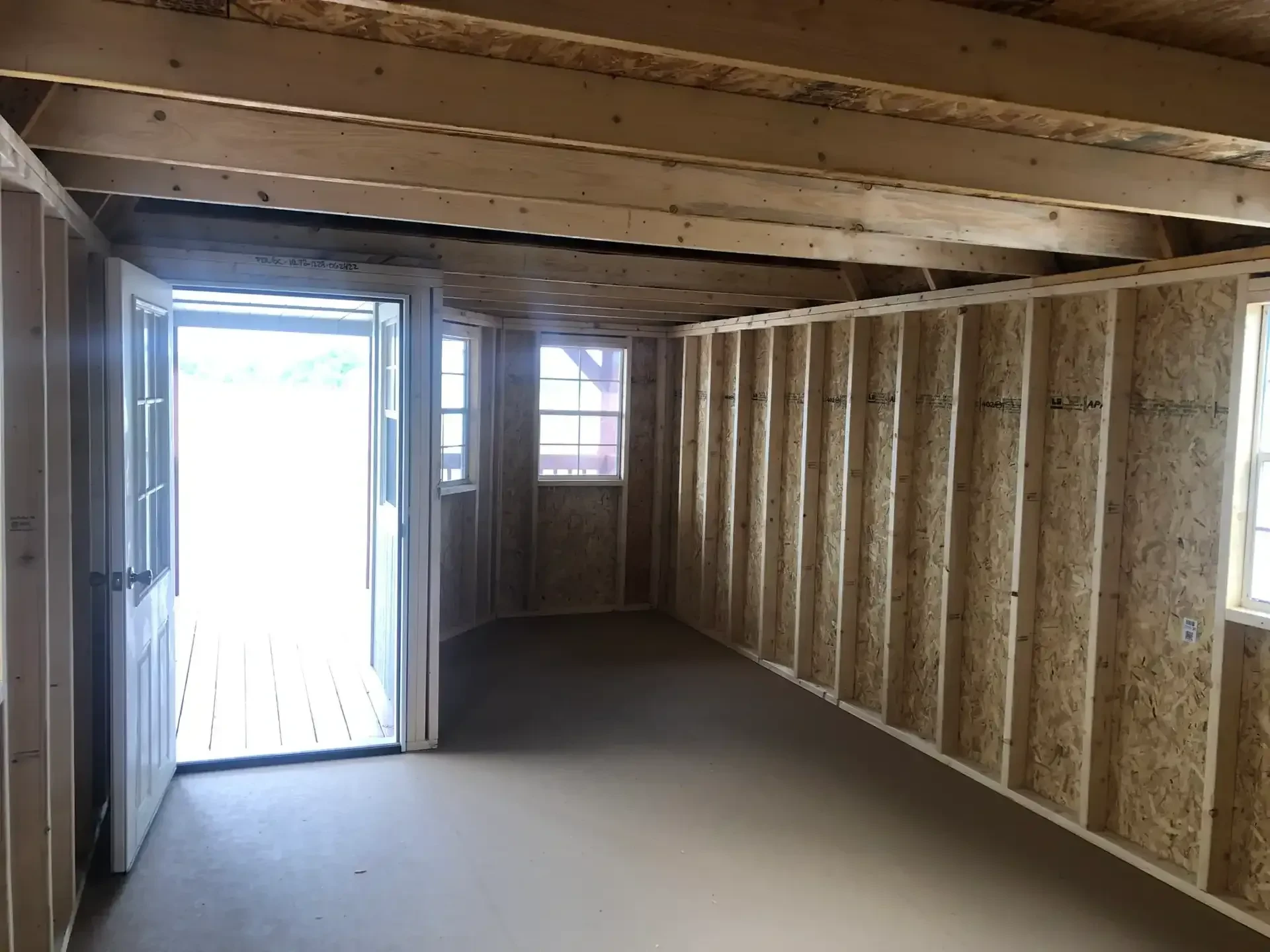 inside a wood lofted cabin looking at the walk-in door which is open