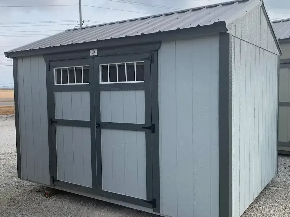 a gray garden shed with transom windows in the double doors