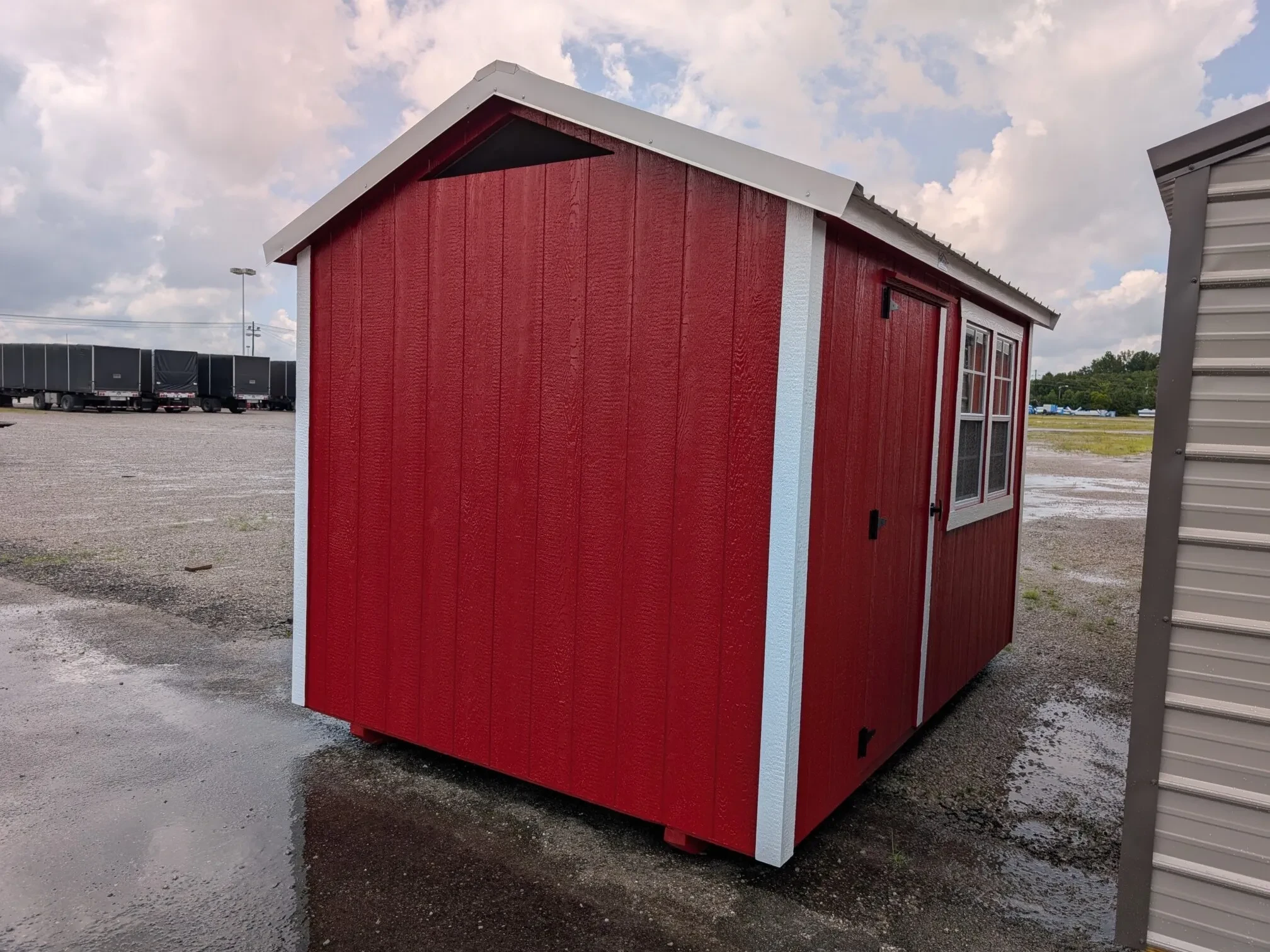a red chicken coop with a walk-in door and two windows side by side