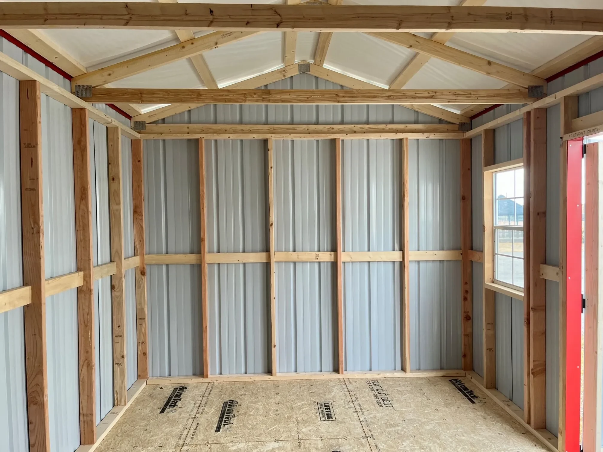 inside a metal garden shed showing the inside of the metal and the wood framing