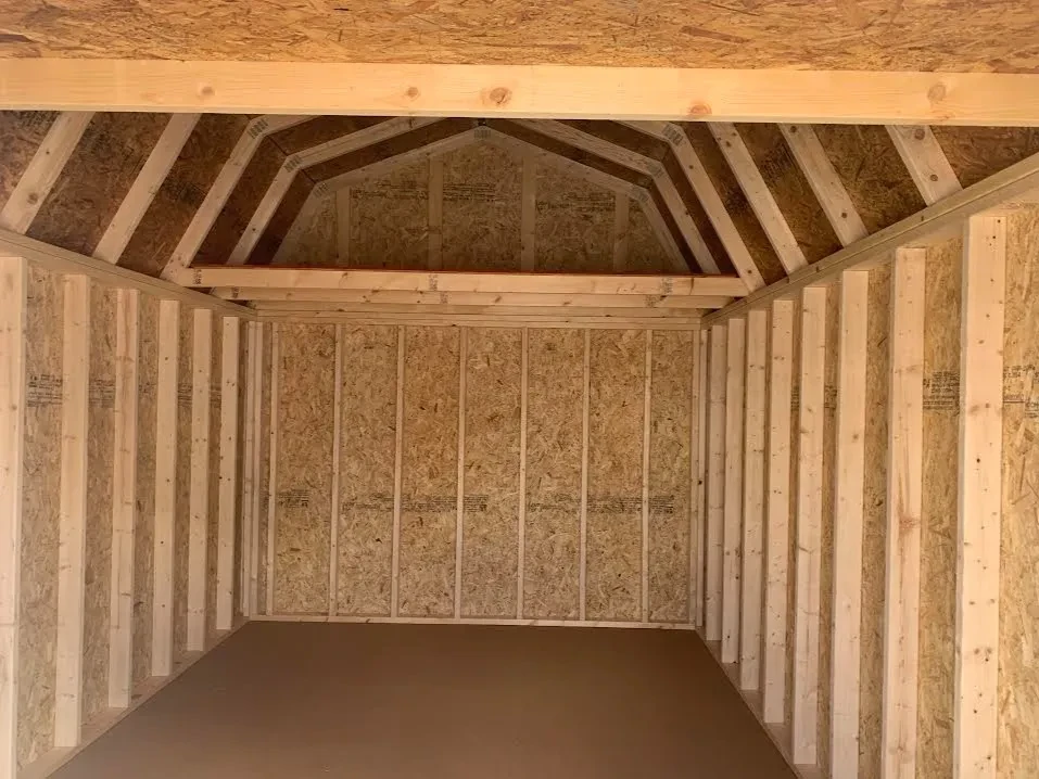 looking inside a wood lofted barn and there is a 4' loft settled on top of the wall framing