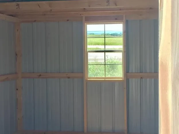 a window inside a metal lofted barn