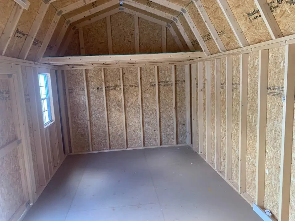 inside a side lofted barn with a loft on the left side and a window on the front wall