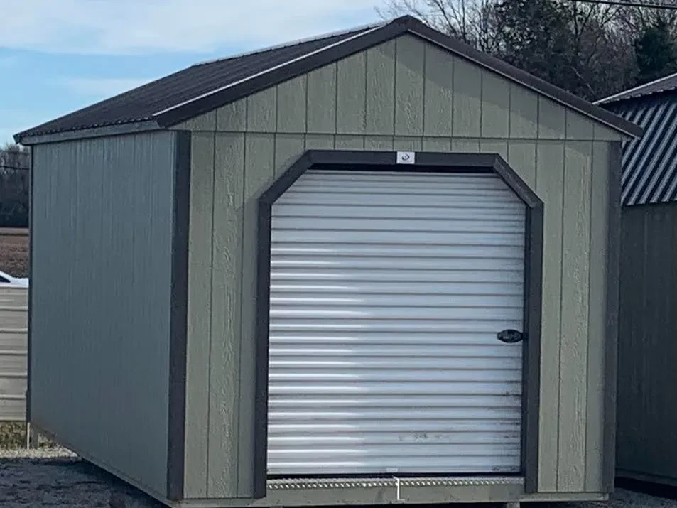 a clay colored wood garage shed with a 6x7 rollup door in the front