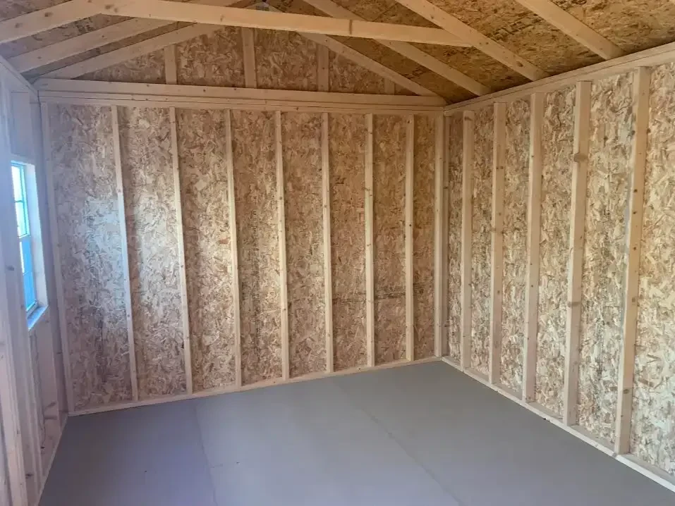 inside a wood garden shed showing the left wall and the floor