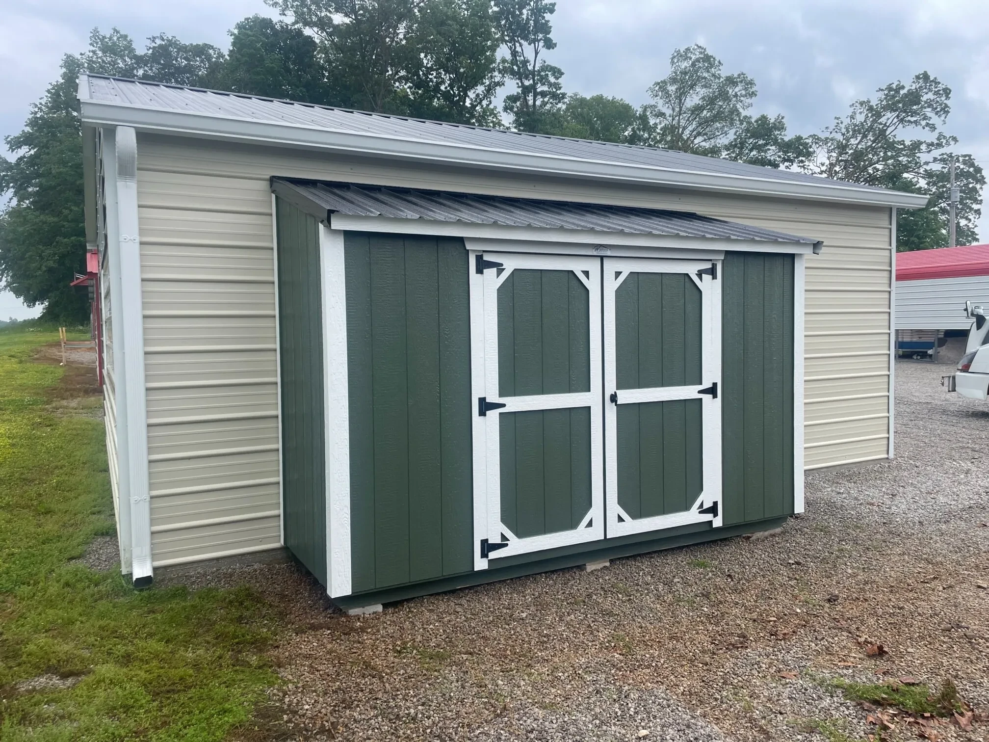 a micro lean-to shed installed on the side of a metal garage