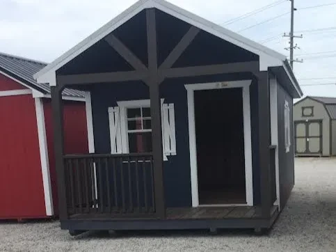 a blue cabin with a vaulted brown porch, it also has a 2x3 window with shutters and a walk-in door
