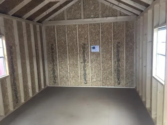 inside a cabin looking at the back wall. There is a window on each of the side walls