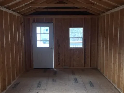 inside a cabin looking at the front wall which has a 9-lite walk-in door next to a 2x3 window