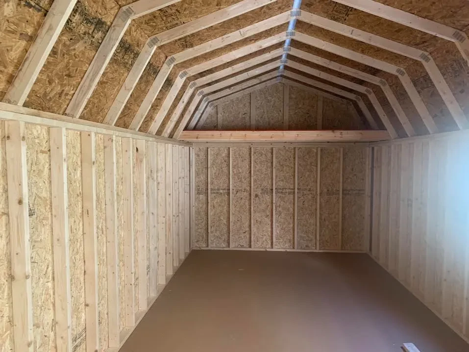 inside a lofted garage looking at the back wall which has a loft