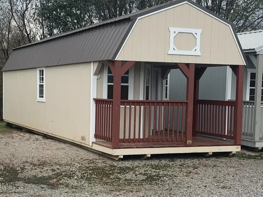 a large lofted cabin with a wrap around porch, multiple windows, and a walk-in door