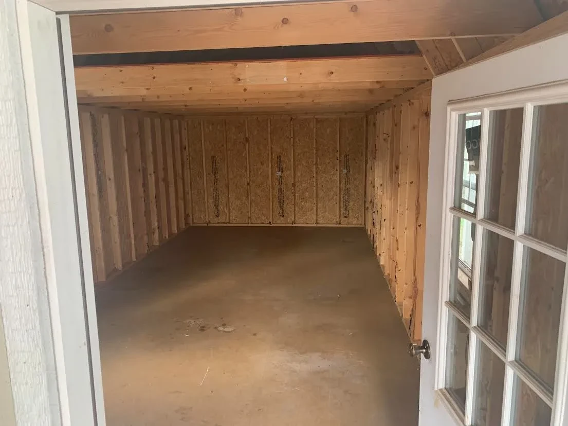 looking inside a lofted cabin towards the back wall, there are large lofts inside