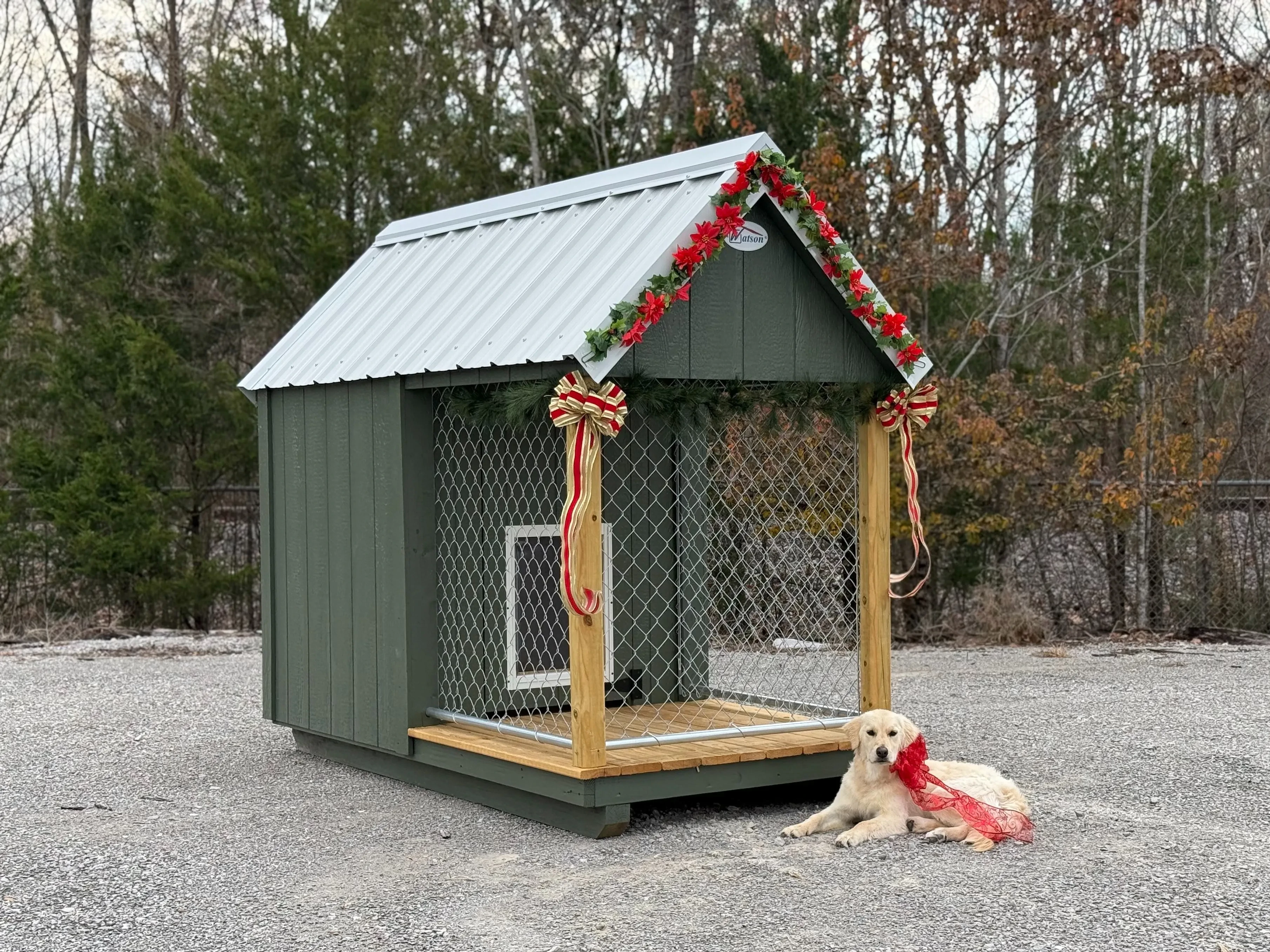 a dark green single dog dog house with an interior portion and a small exterior run