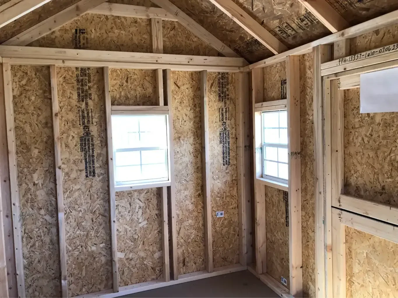 inside a wood playhouse looking at the windows all around