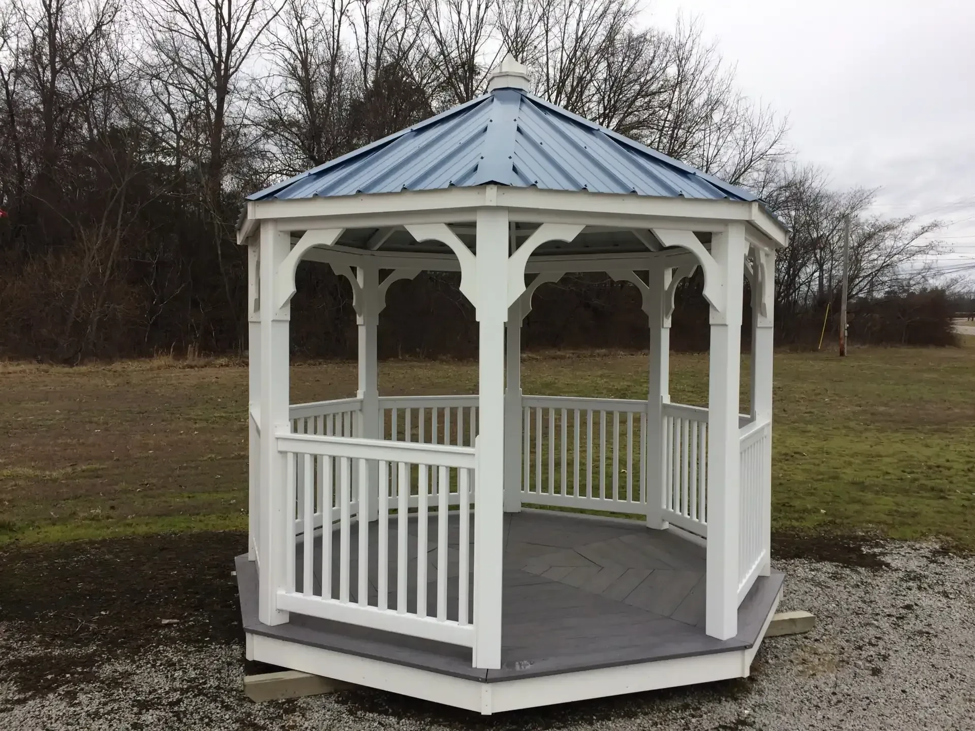 a white gazebo with white posts and white railings, and a blue metal roof