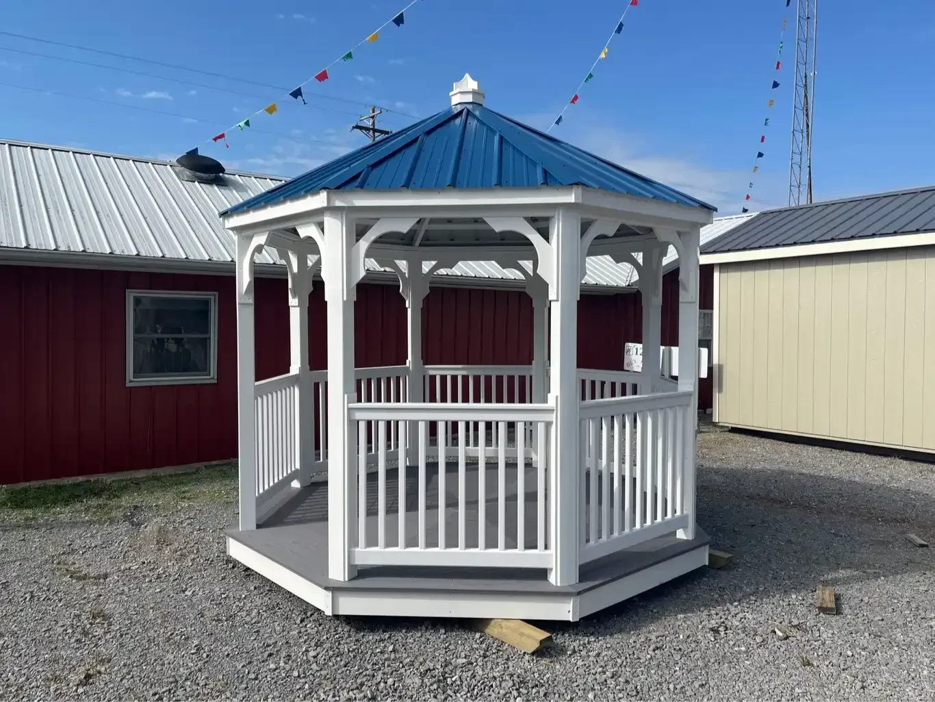 a white vinyl gazebo with an opening to walk in, it has gray vinyl flooring and a blue metal roof