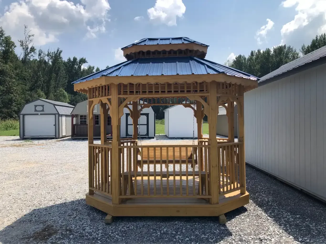 a honey gold stained teahouse with posts and railings, it also has a double metal blue roof
