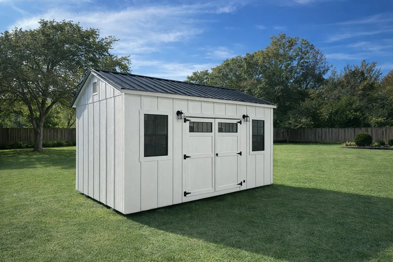 White shed in backyard with board & batten siding