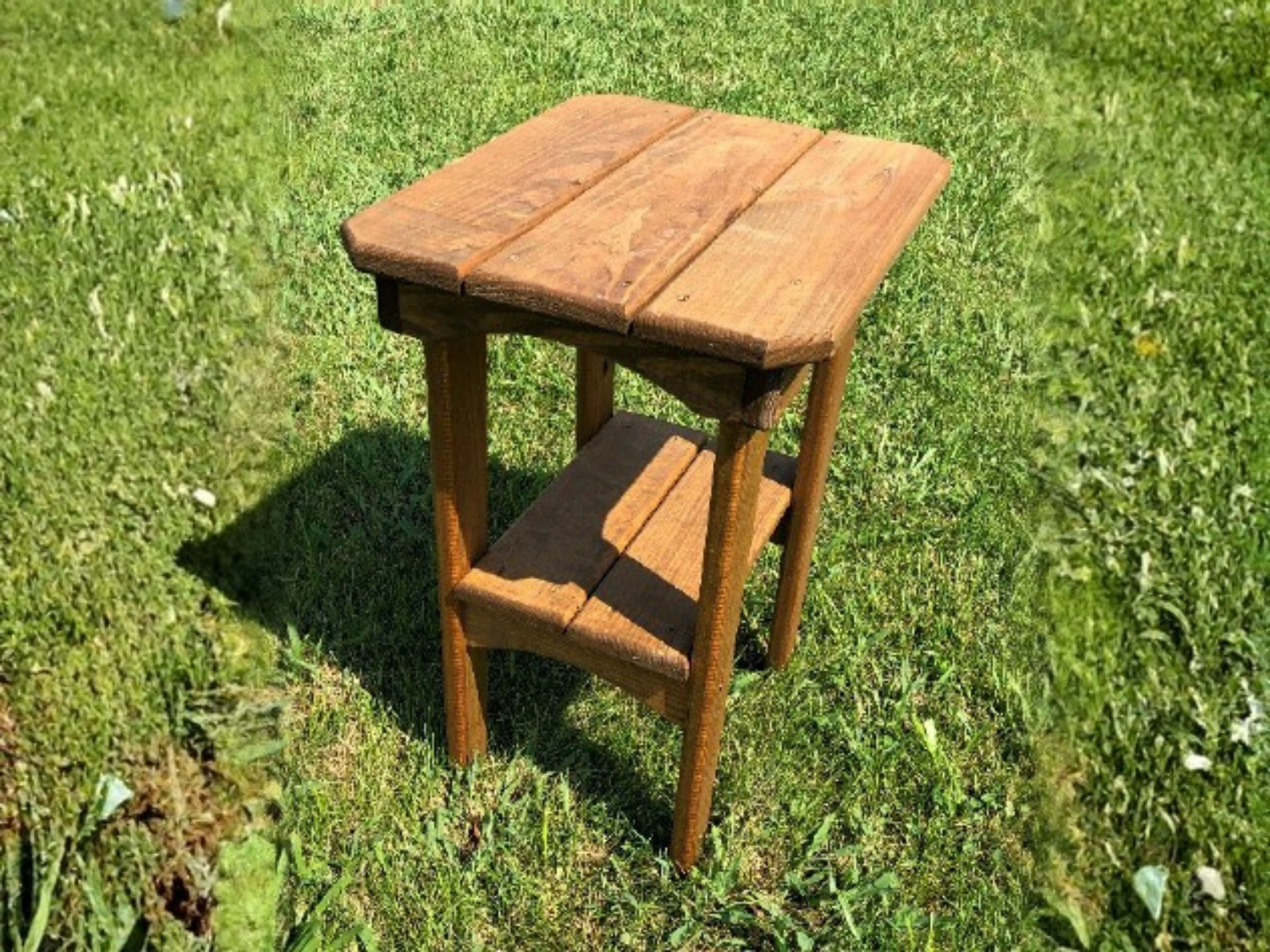 Wood balcony end table setting in the grass